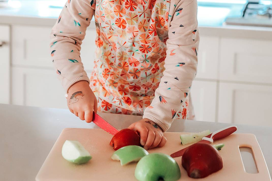 niño cortando fruta